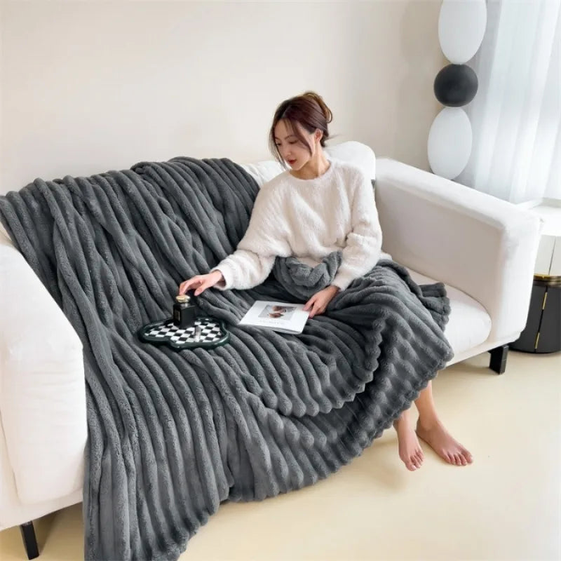 Dark gray ribbed faux fur throw blanket draped over a sofa