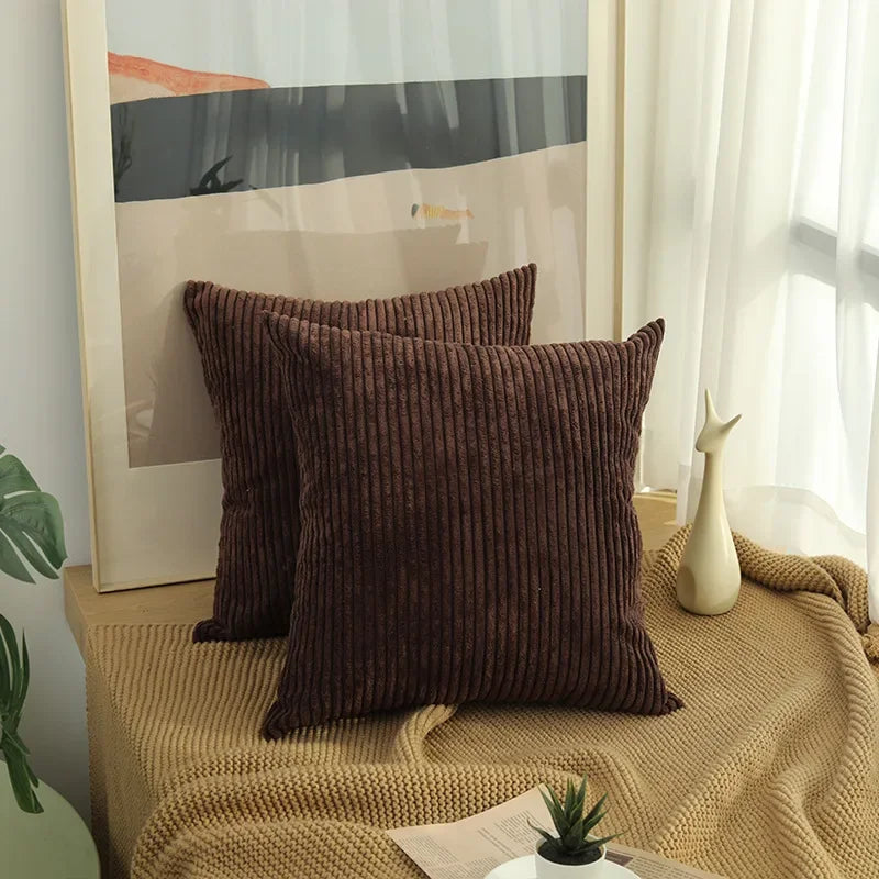 Two dark coffee corduroy pillow covers on a window bench