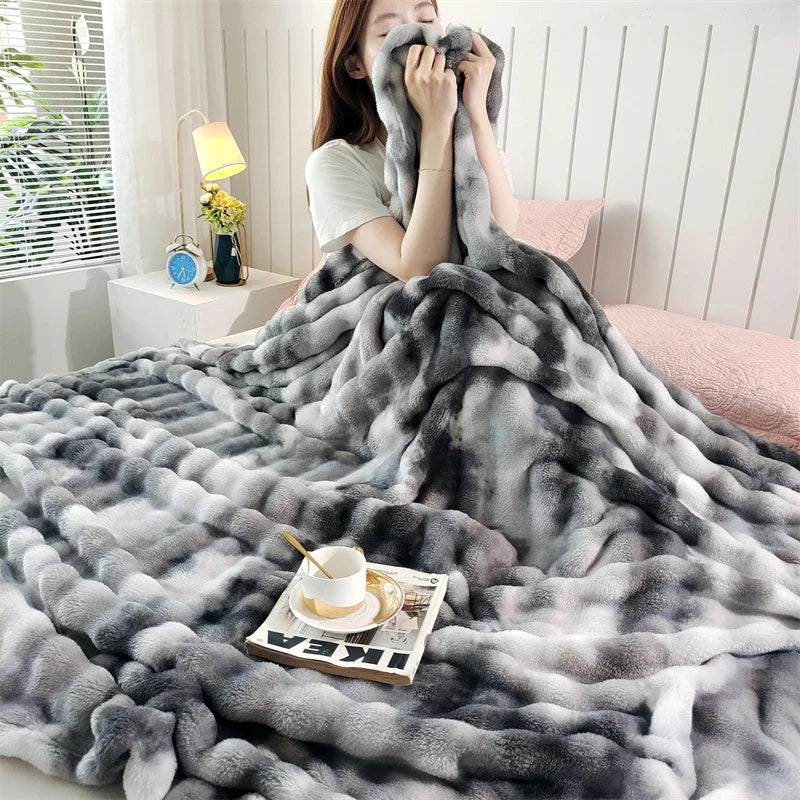 Charcoal gradient bubble faux fur throw wrapped around a person on a bed (supplier photo)