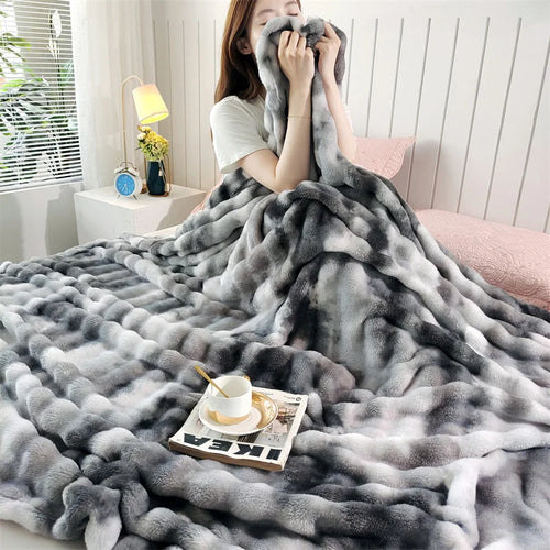 Charcoal gradient bubble faux fur throw wrapped around a person on a bed (supplier photo)
