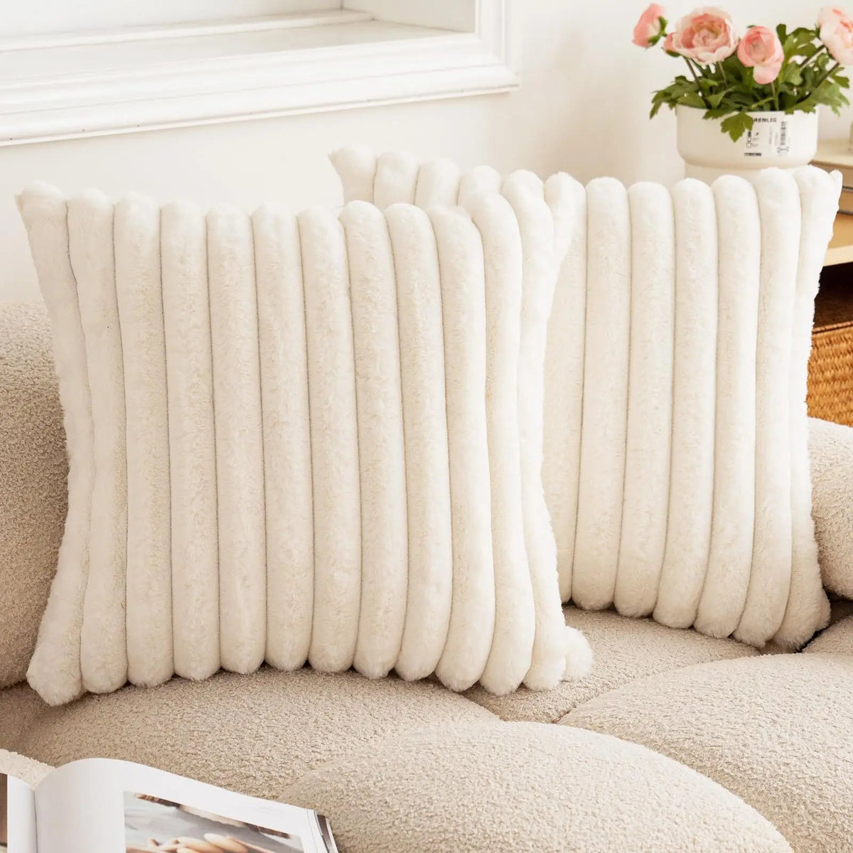 Ivory striped faux fur pillow covers propped against a sofa
