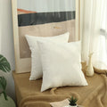 Two white corduroy pillow covers on a window bench