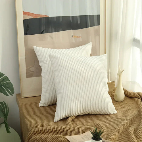 Two white corduroy pillow covers on a window bench
