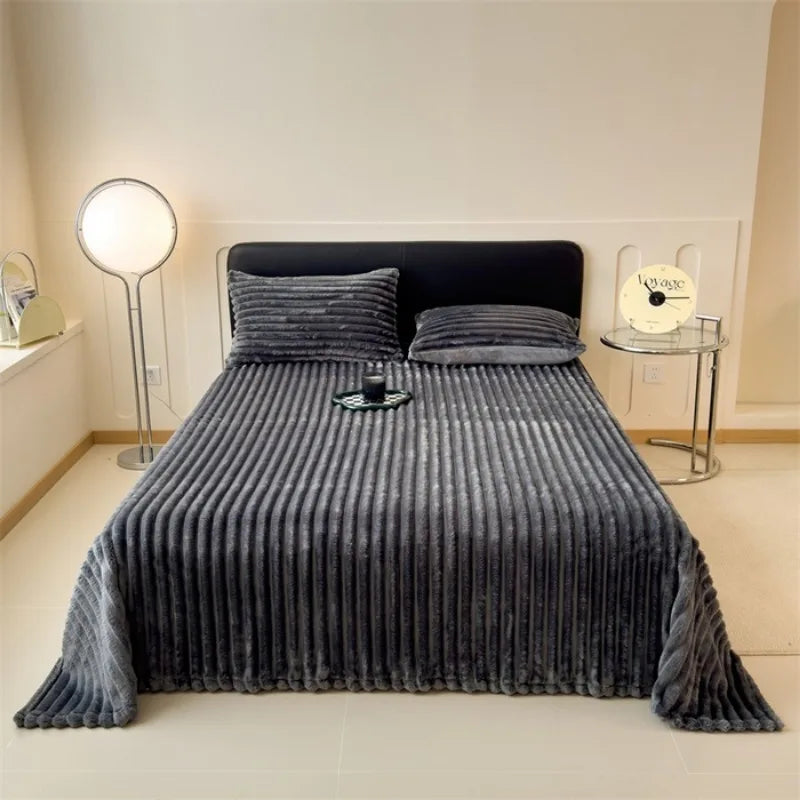 Dark gray ribbed faux fur throw blanket spread over a bed