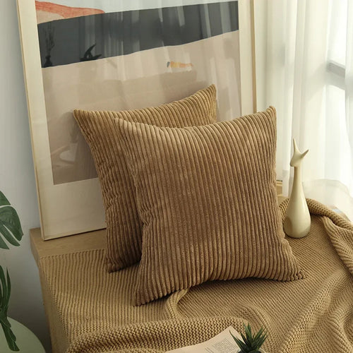 Two light coffee corduroy pillow covers on a window bench