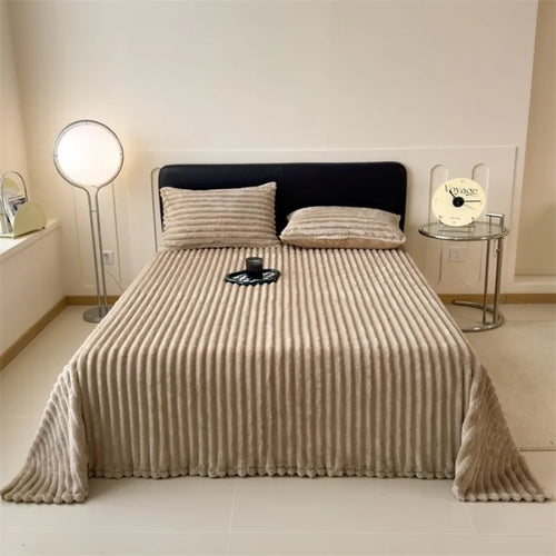 Khaki ribbed faux fur throw blanket spread over a bed