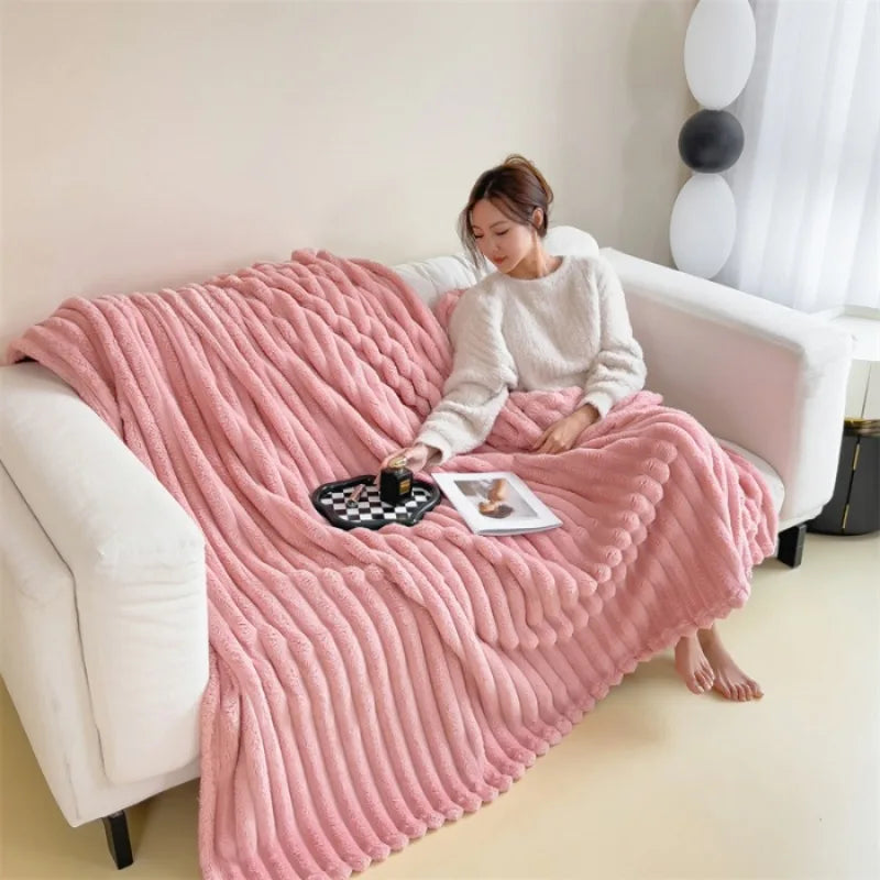 Pink ribbed faux fur throw blanket draped over a sofa
